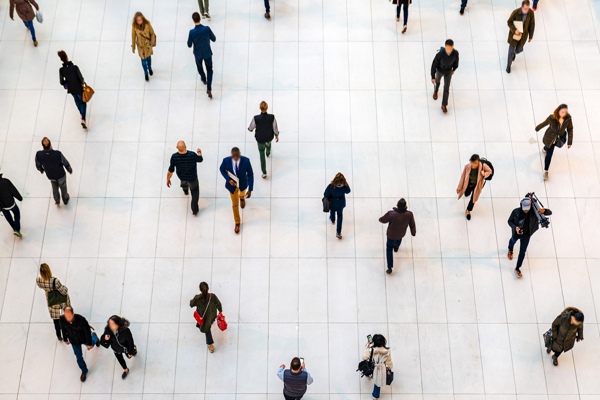 overhead view of people walking in large metropolitan area, white tile ground