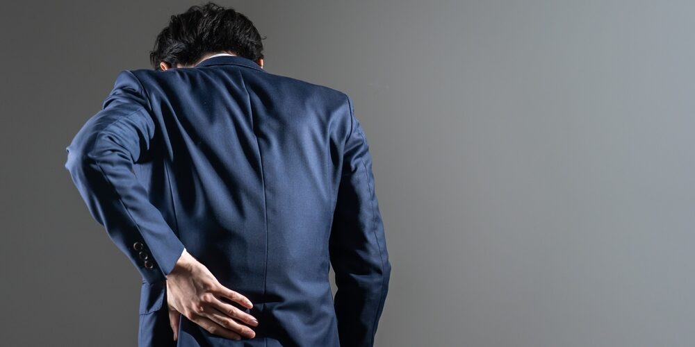 Man in suit experiencing back pain