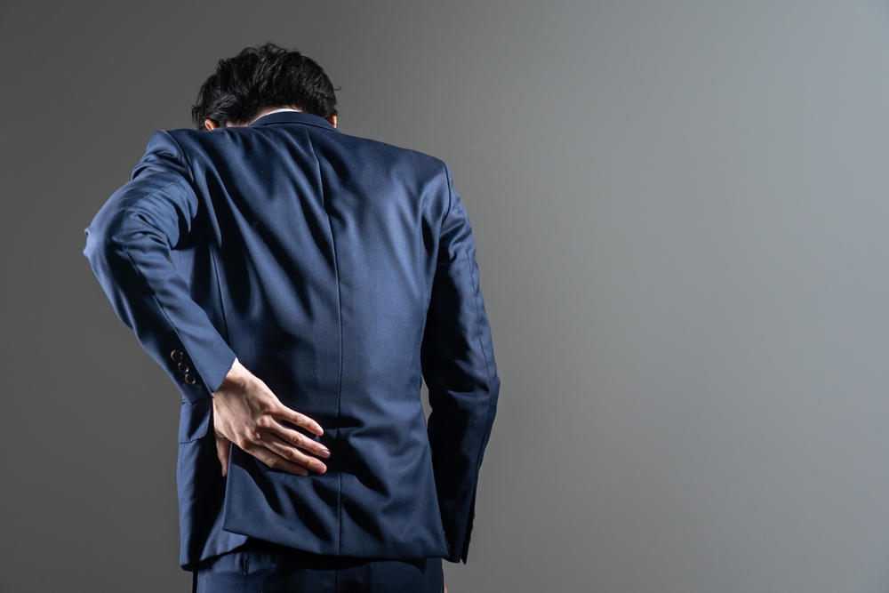 Man in suit experiencing back pain