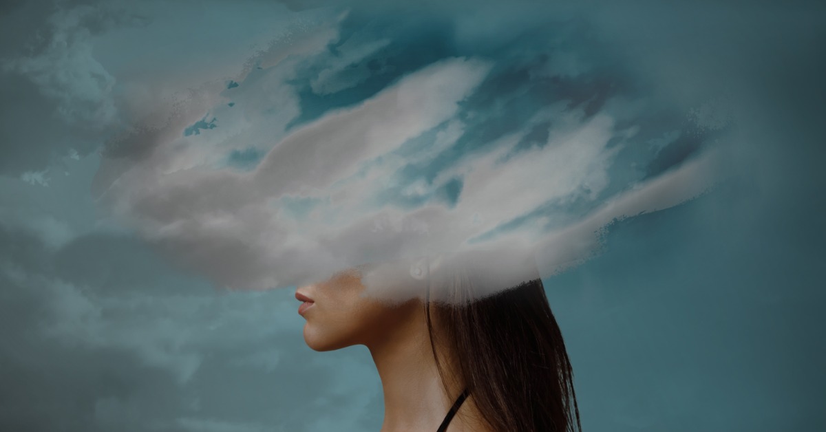 A side profile of a woman with dark hair against a blue sky background. A gray-white cloud covers her eyes and forehead.