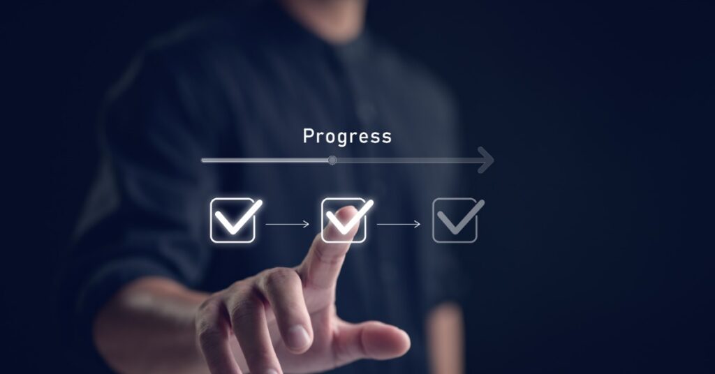 A person touches one of three digital checkmark icons. A progress bar and an arrow are above the row of boxes.